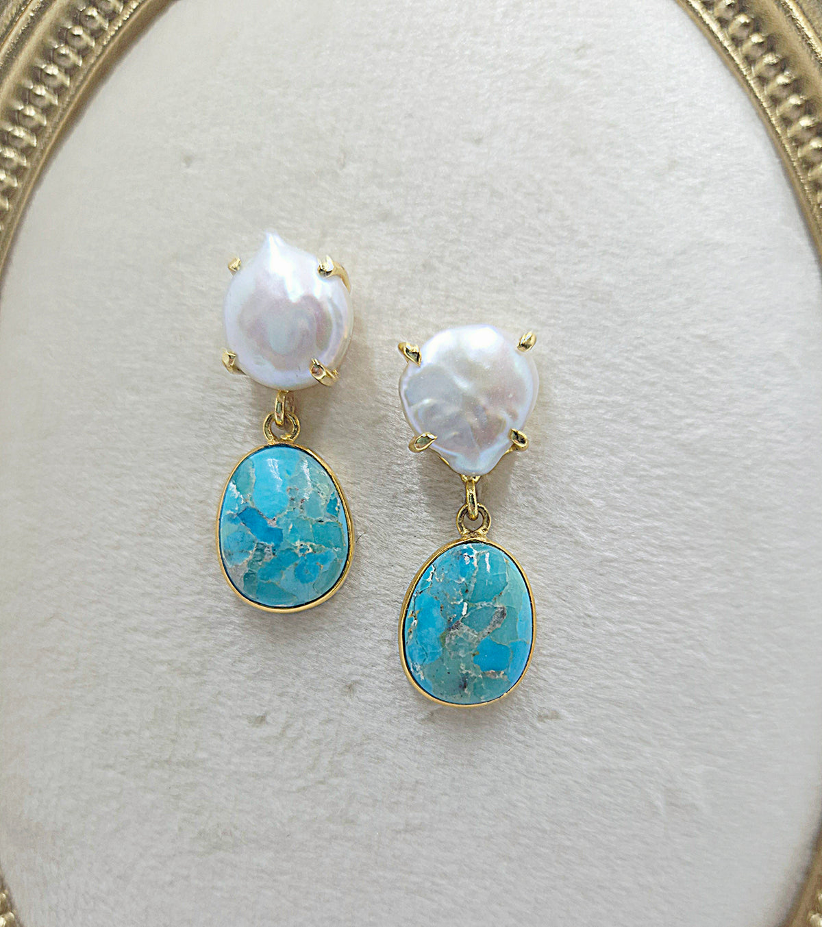 Close-up of pearl cushion studs and Kingman turquoise drops framed in gold-plated bezels