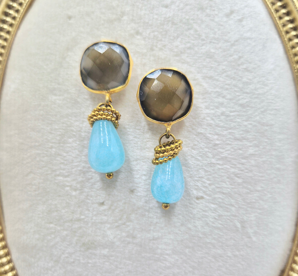 Close-up of faceted grey chalcedony studs and pale blue Tianhe stone drops