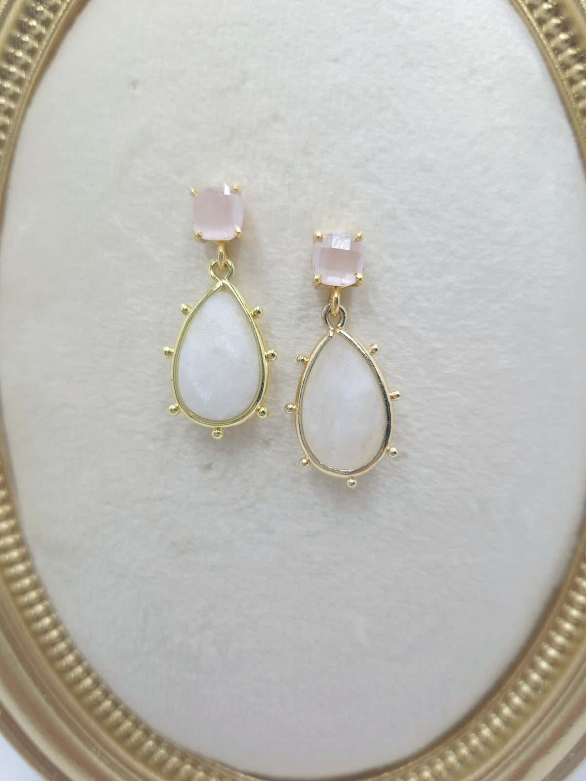 Close-up of pink chalcedony cushion studs, white crystal drops, and gold-tone beaded frames